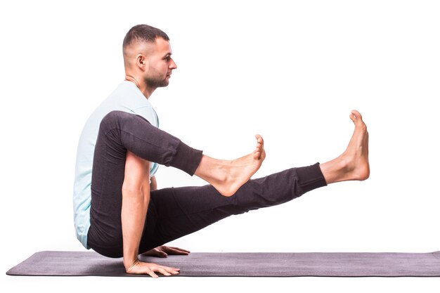 Young man is making yoga isolated over white background