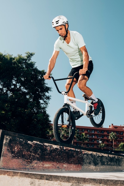 Free photo young man jumping with bicycle