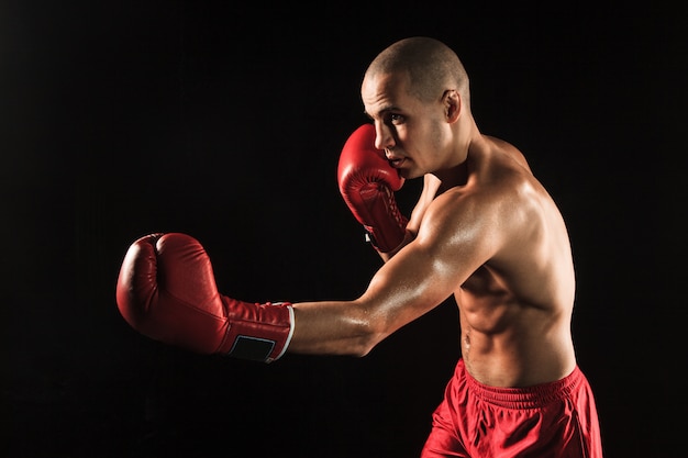 Free Photo the young man kickboxing on black