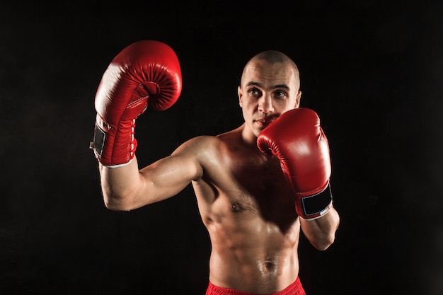 young man kickboxing on black