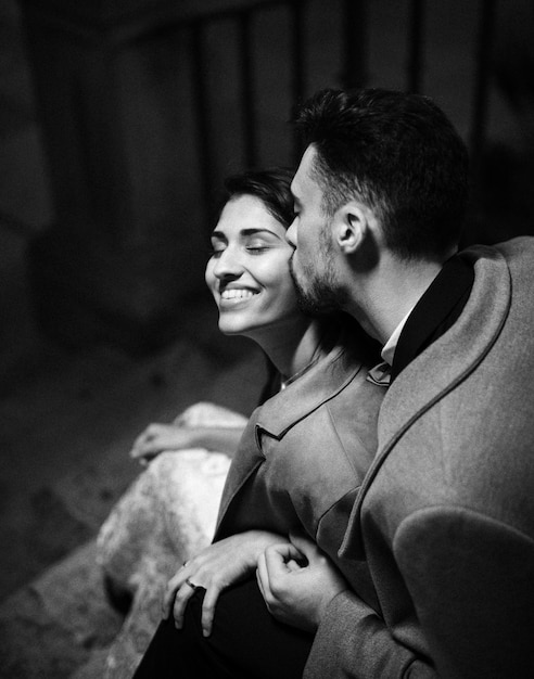 Free photo young man kissing happy woman on stairs