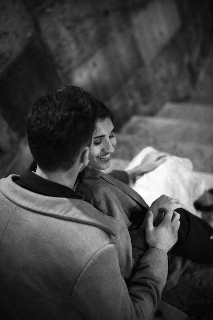 Free photo young man kissing happy woman on steps