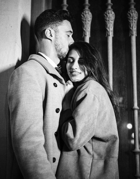 Free photo young man kissing woman on forehead in street