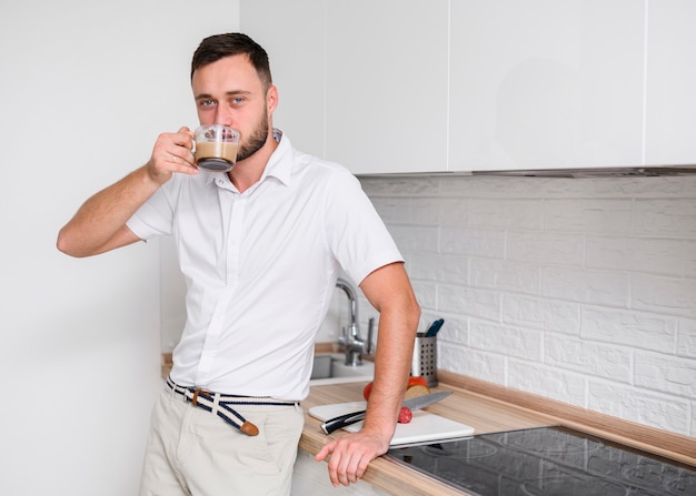 Young man in the kitchen enjoying a coffee