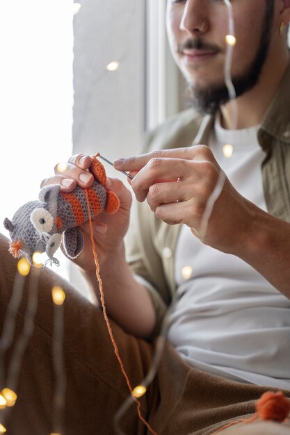 Young man knitting while relaxing