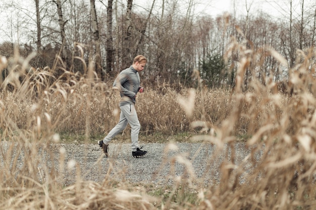 Free Photo young man leaping over the puddle on dirt road