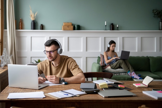 Free photo young man listening to music during study session