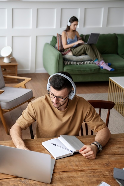 Free Photo young man listening to music during study session