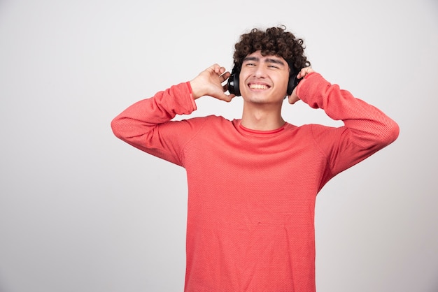 Young man listening to music with headphones happily.