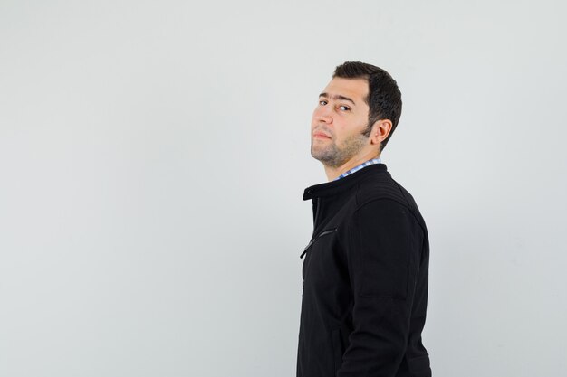 Young man looking at camera in shirt, jacket and looking confident .