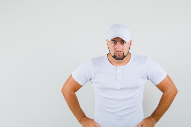 Free Photo young man looking forward in white t-shirt and looking careful. front view.