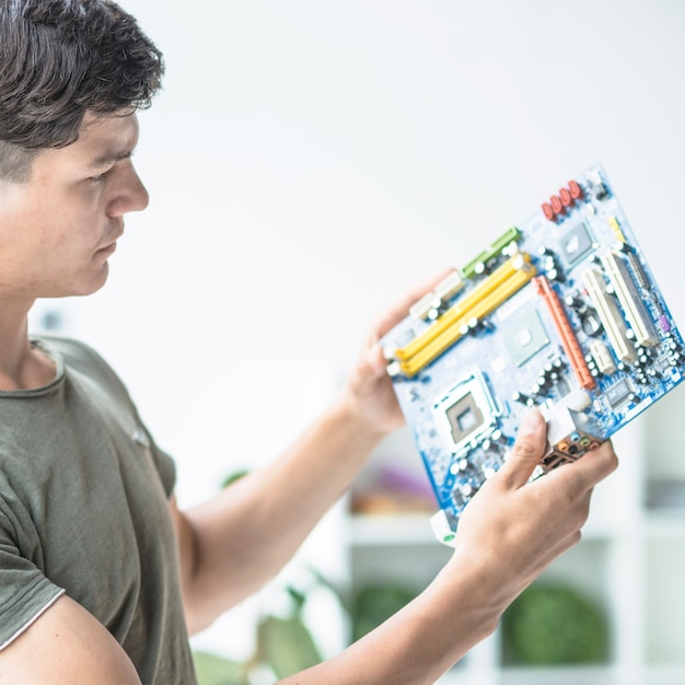 Free photo young man looking at motherboard circuit