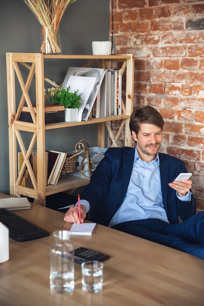 Free photo young man, manager, team led return to work in his office after quarantine, feels happy and inspired