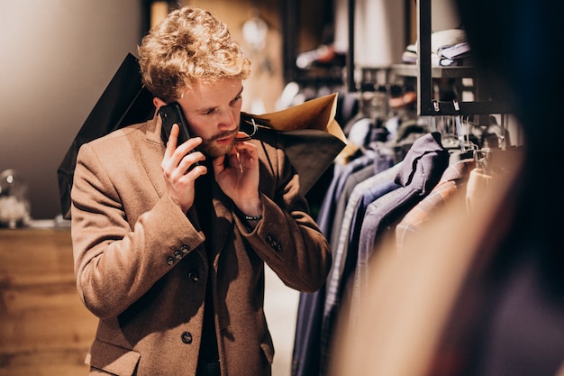 Young man at menswear shop talking on the phone