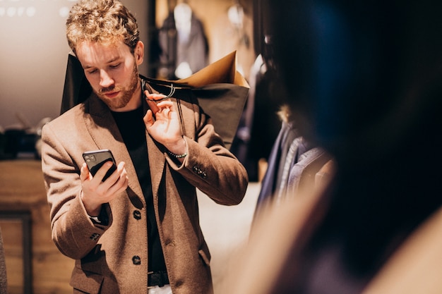 Free photo young man at menswear shop talking on the phone