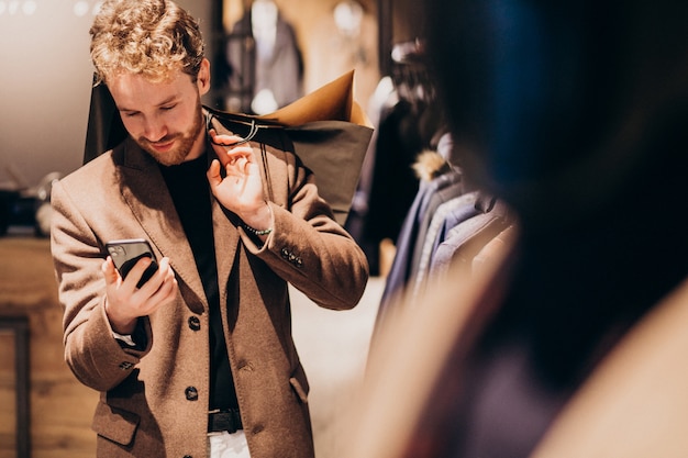 Young man at menswear shop talking on the phone