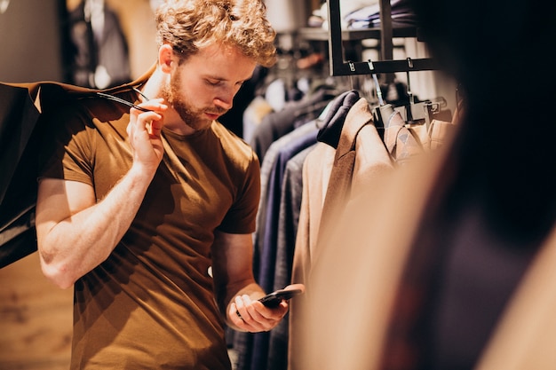 Young man at menswear shop talking on the phone