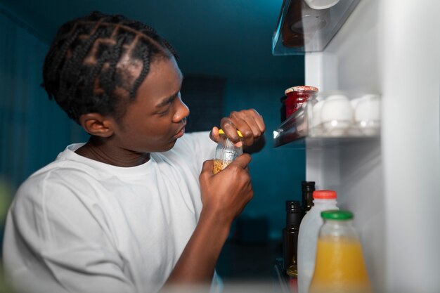 Young man opening the fridge at home for a snack in the middle of the night