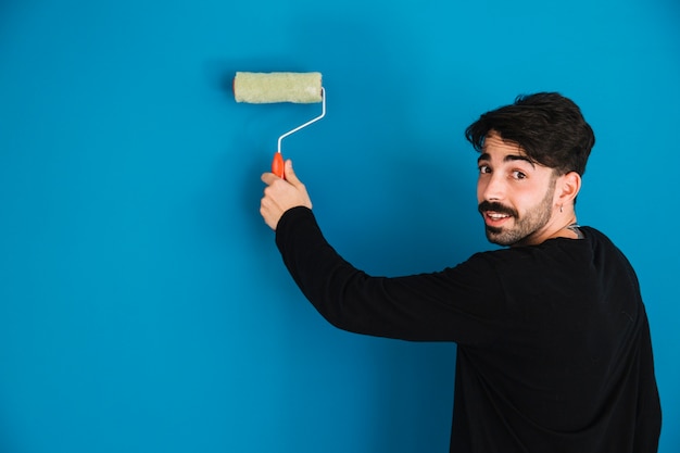 Young man painting wall