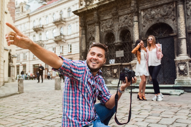 Young man photographer taking pictures, taking photos with digital camera to her friends