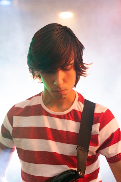 Young man playing guitar music at a local event