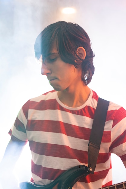 Young man playing guitar music at a local event