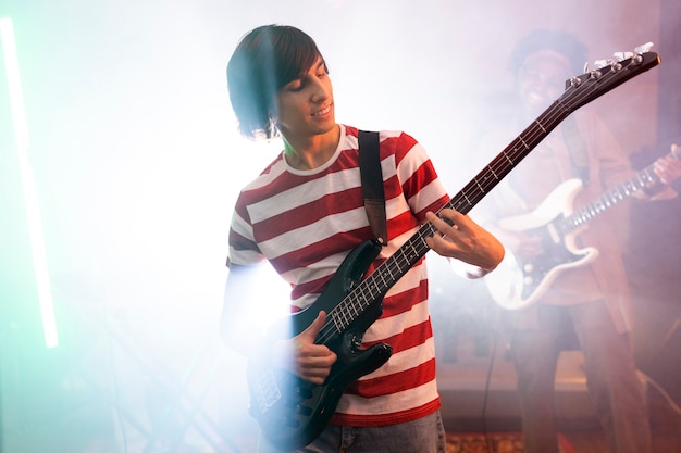 Young man playing guitar music at a local event