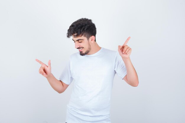 Young man pointing both side in t-shirt and looking happy