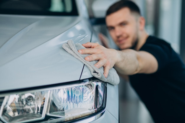 Free photo young man polishing his car with rag