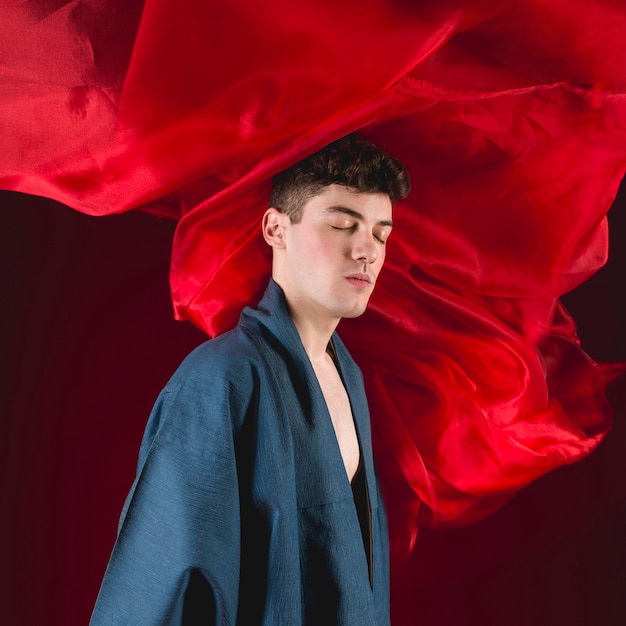 Free photo young man posing with red cloth