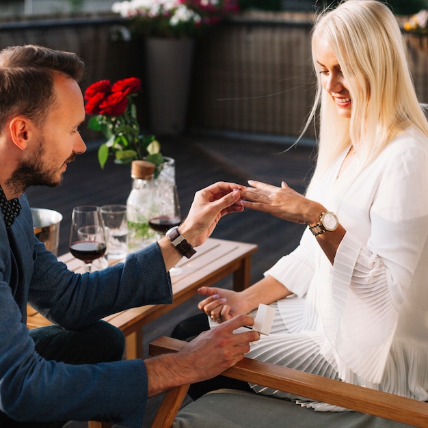 Free photo young man proposing to smiling beautiful woman outdoors