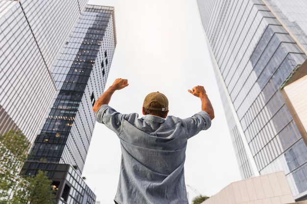 Free photo young man raising his fists in the air