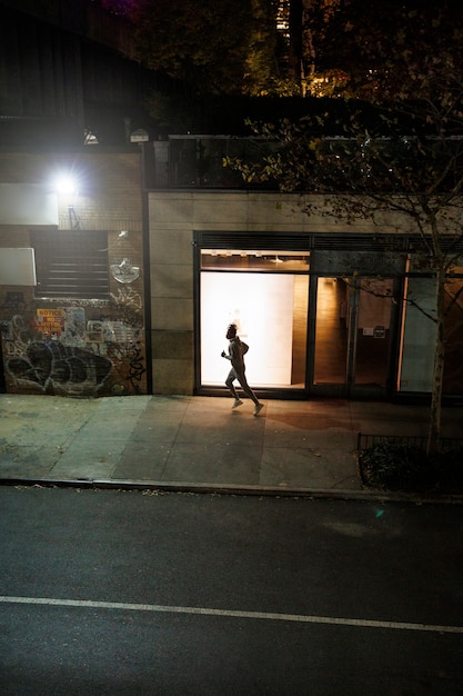 Free photo young man running at night in the city streets