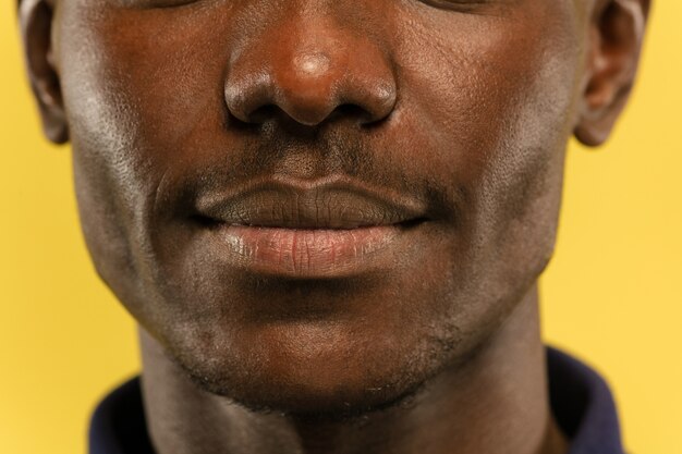 Young man's close up portrait on yellow wall