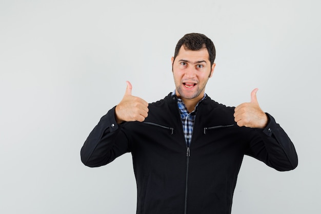 Free photo young man showing double thumbs up in shirt, jacket and looking confident. front view.