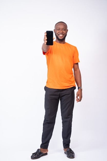 Young man showing his phone screen isolated on a white background