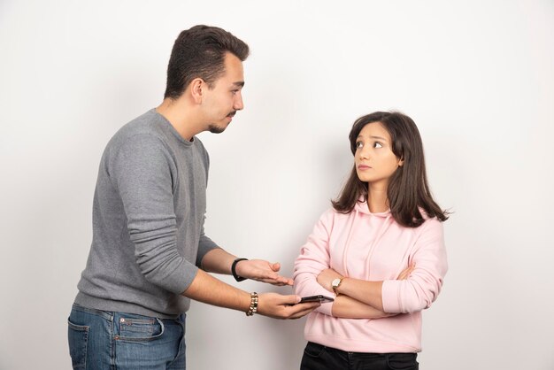 Young man showing his telephone to woman.