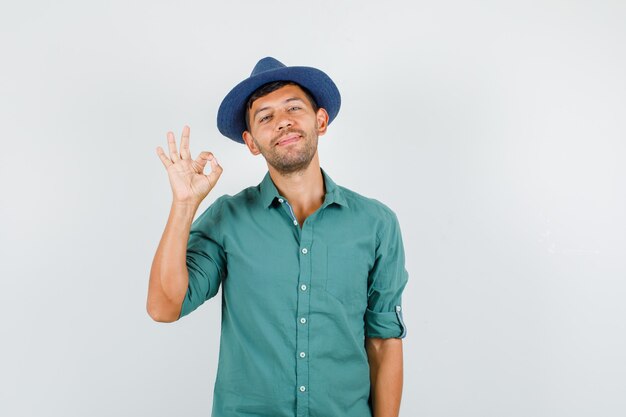 Young man showing ok gesture in shirt