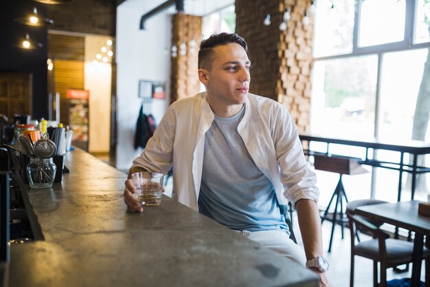 Young man sitting at bar counter in the restaurant