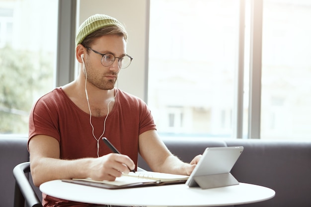 Young man sitting in cafe listening to music