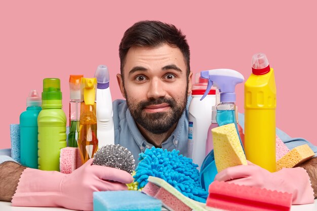 Young man sitting next to cleaning products