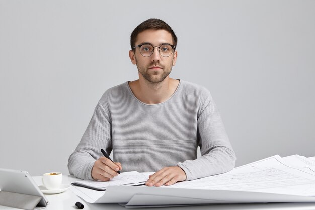 Young man sitting at desk and doing paperwork