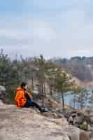 Free photo young man sitting on the edge of a cliff