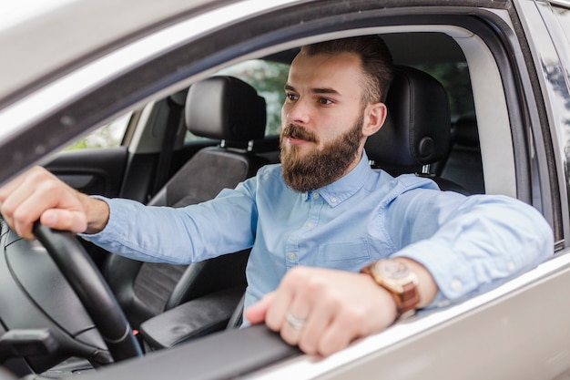 Young man sitting inside car