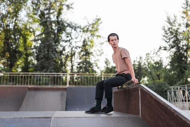 Young man sitting on a skateboard