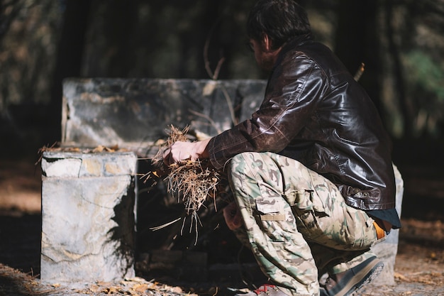 Young man sitting with foliage