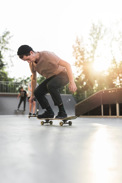 Free photo young man skateboarding in the street