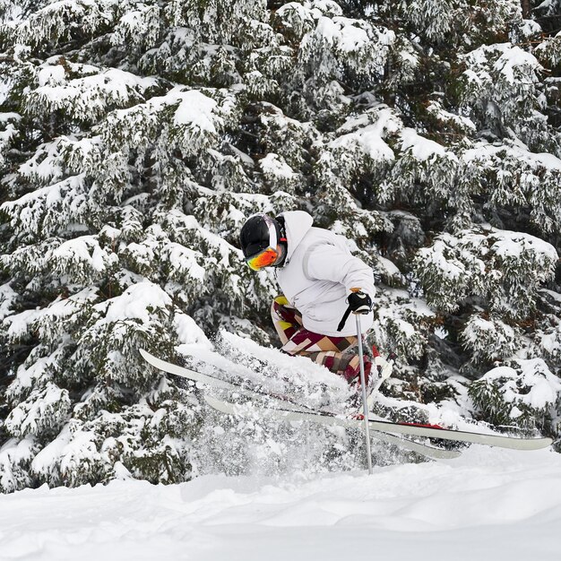 Young man on skis doing tricks with ski poles