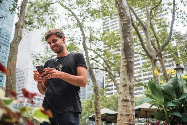 Young man smiling while looking at the phone screen