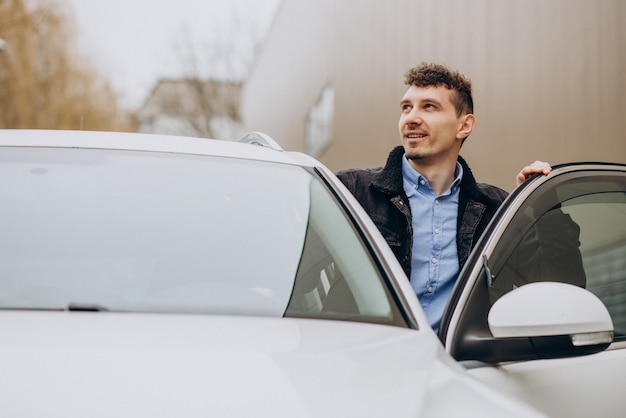 Free photo young man standing by the car